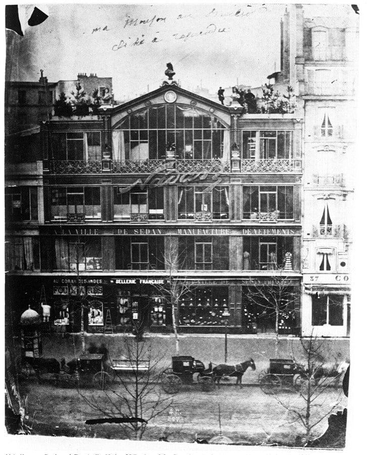 Paris'te Boulevard des Capucines üzerinde, cam cepheli Nadar fotoğraf atölyesinin bulunduğu bina ve önündeki arabalar