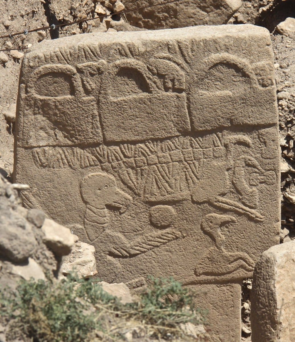 Göbeklitepe'nin 43 numaralı Akbaba Taşı: üstte çanta biçimli motifler, altta akbaba, kuşlar ve başka hayvan kabartmaları