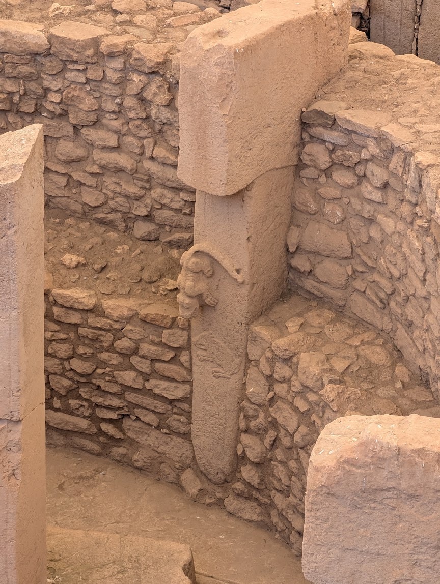 Göbeklitepe'de 27 numaralı dikilitaşta aşağı doğru inen yırtıcı hayvan ve yaban domuzu kabartması