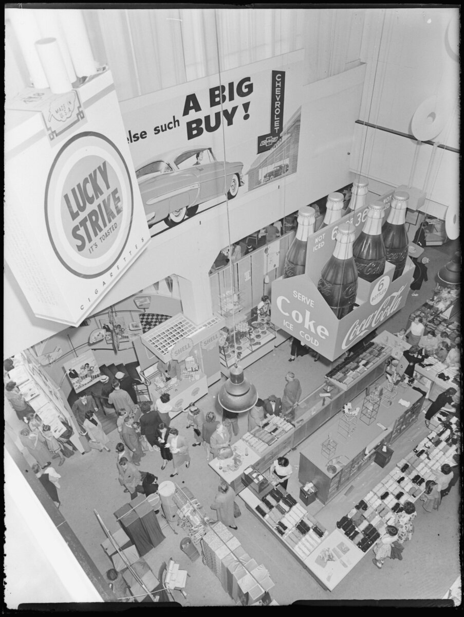 1955'te Rotterdam'daki Bijenkorf mağazasının vitrinlerinde Coca-Cola ve Lucky Strike reklamları