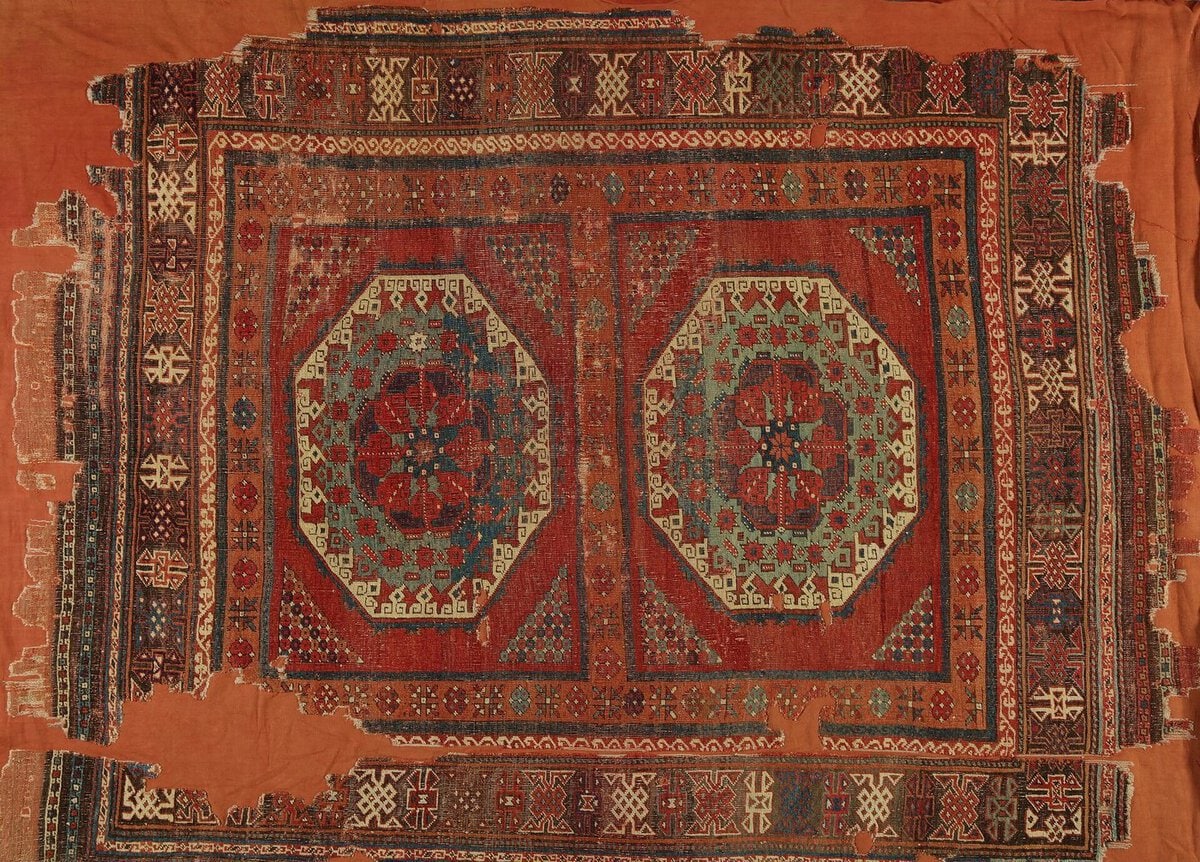 Kırmızı zeminde iki büyük sekizgen madalyonlu, kufi benzeri bordürlü Holbein tipi Anadolu halısı